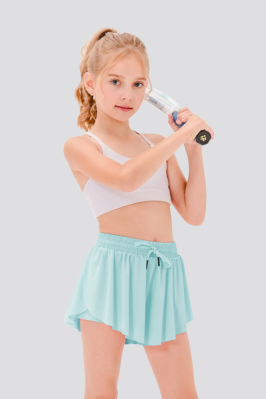 Girl holding a tennis racket, wearing light blue butterfly shorts